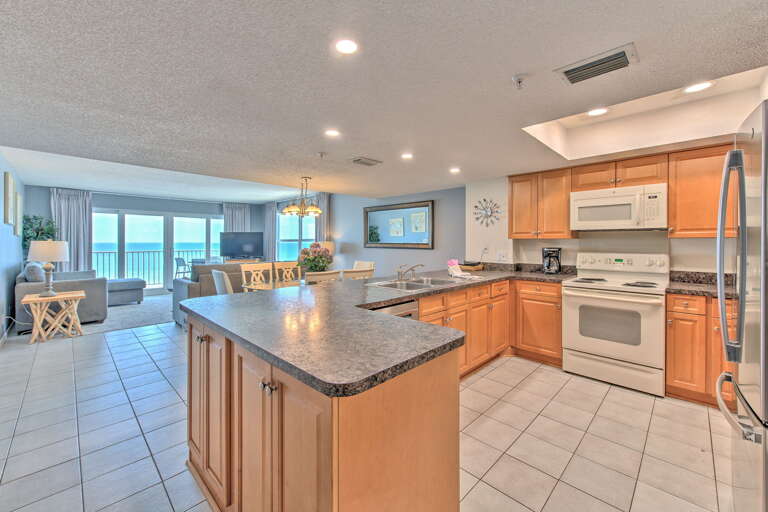 Your spacious kitchen features granite counters and modern appliances, opening to a bright living area with stunning ocean views.