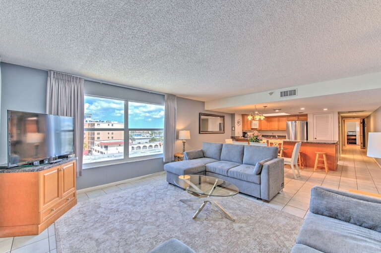 Unwind in your spacious living room with plush seating, city views, and open-concept design flowing into a modern kitchen.