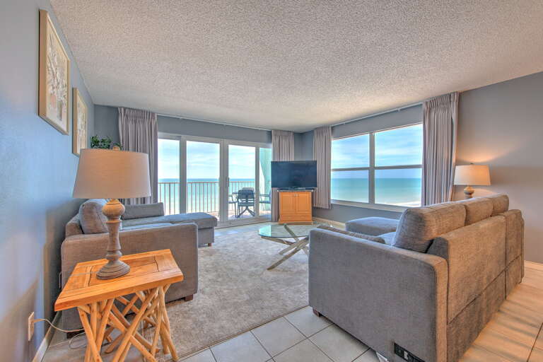 Wake up to endless ocean views from your comfortable living room, where plush seating and a private balcony create the perfect coastal retreat.