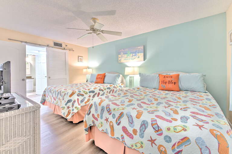 Drift off to peaceful sleep in your coastal-themed bedroom with twin beds dressed in cheerful flip-flop bedding and gentle turquoise walls.