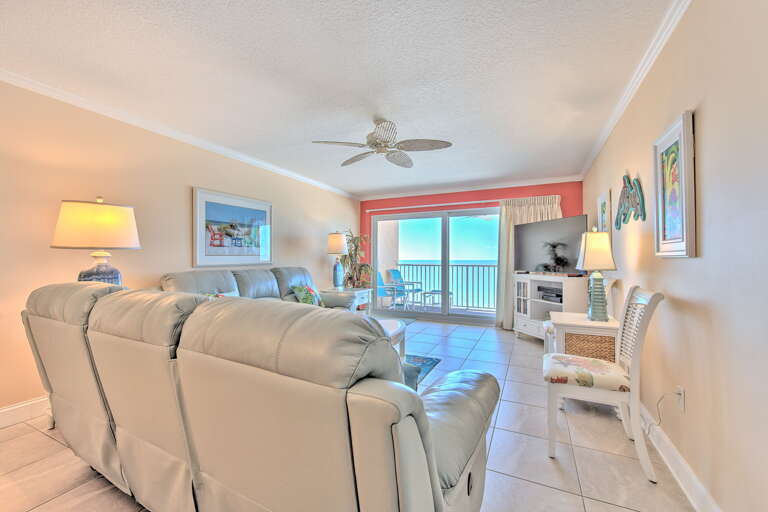 Your oceanfront living room offers stunning sea views through floor-to-ceiling windows, with comfortable seating and gentle ceiling fan breezes for ultimate relaxation.