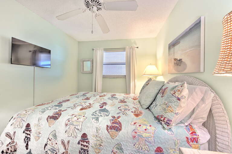 Drift into dreams in your coastal bedroom, where playful linens and gentle ceiling fan breezes create the perfect retreat after beach adventures.