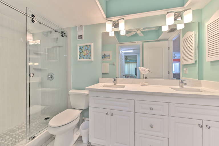 Refresh in your bright, coastal-inspired bathroom with modern double vanity, spacious glass shower, and soothing seafoam walls.