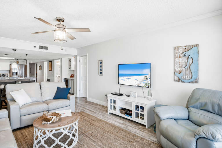 Relax in your bright coastal living room with plush seating, modern TV, and nautical touches that create the perfect beach getaway atmosphere.