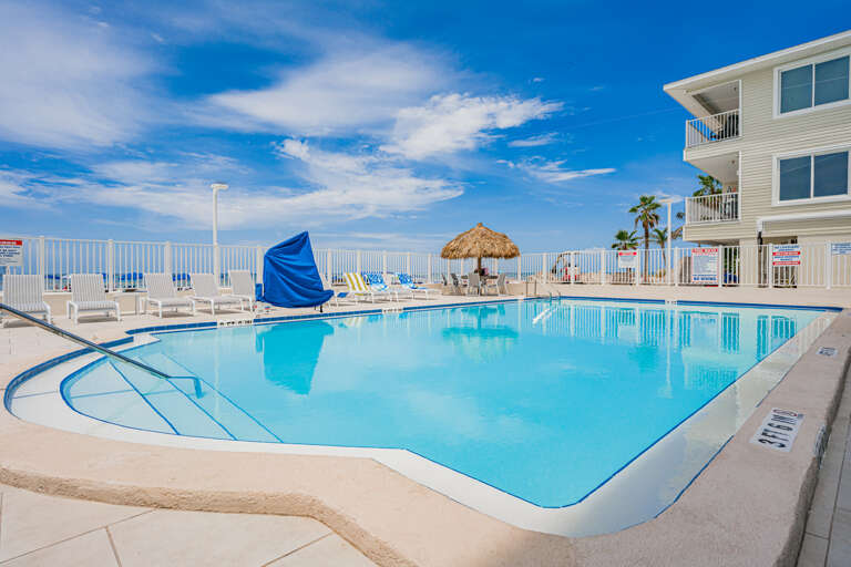 Dive into crystal-clear waters surrounded by tropical charm. This sparkling pool beckons you to unwind under blue skies.