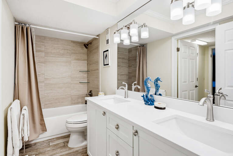 Unwind in your spa-inspired bathroom featuring a soaking tub, dual vanity, and elegant coastal touches that invite relaxation.