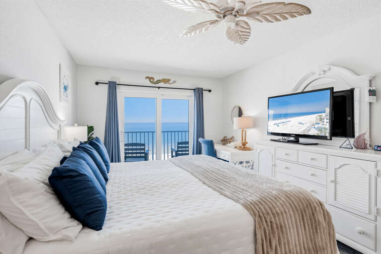 Wake up to stunning ocean views from your private balcony, while coastal breezes from the ceiling fan keep you comfortable in this serene beachfront bedroom.