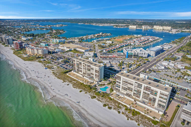 Spectacular beachfront property positioned directly on pristine white sand with bay waters beyond.