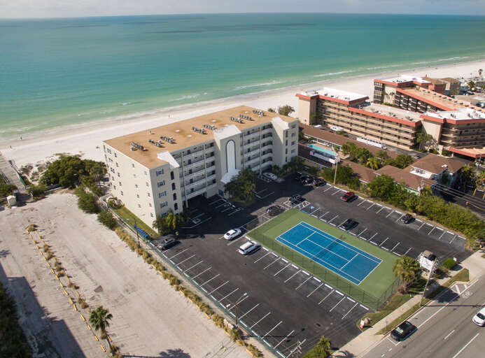 Beachfront property with tennis court and parking, steps from pristine white sand beaches and turquoise Gulf waters.