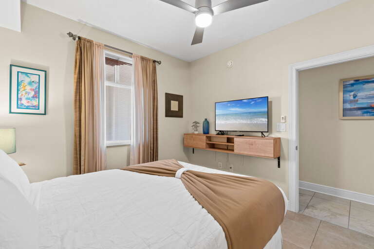 Cozy guest bedroom with a comfortable bed and smart TV for easy streaming—perfect for relaxing nights in.