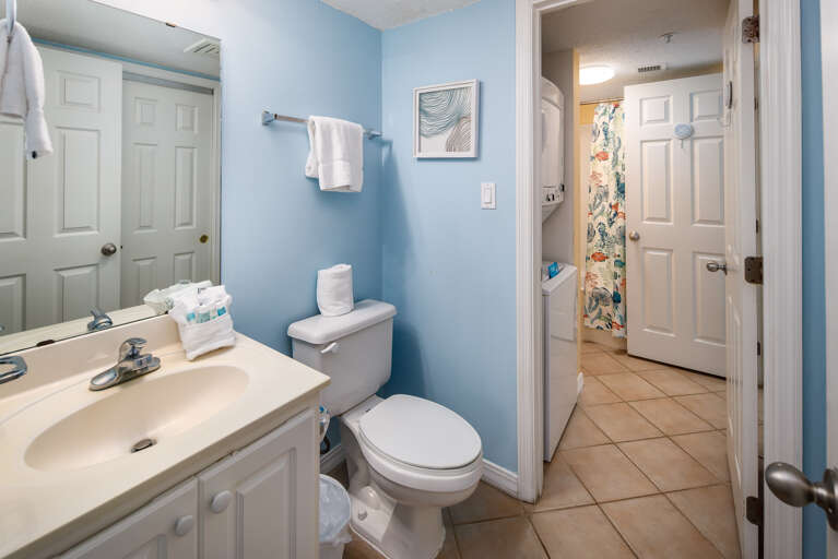 The bathroom has facilities beside the bedroom and the bunk area, with the shower and the washer and  dryer in between them.