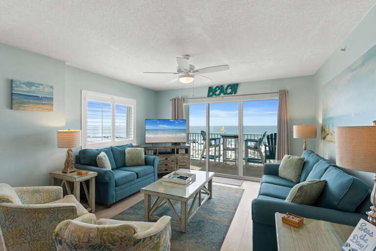 Living Room: Bright beach vibes with stunning views, comfy seating, and vibrant decor await you!