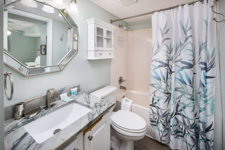 The second full bath in the condo can be accessed from the hallway and the guest bedroom.