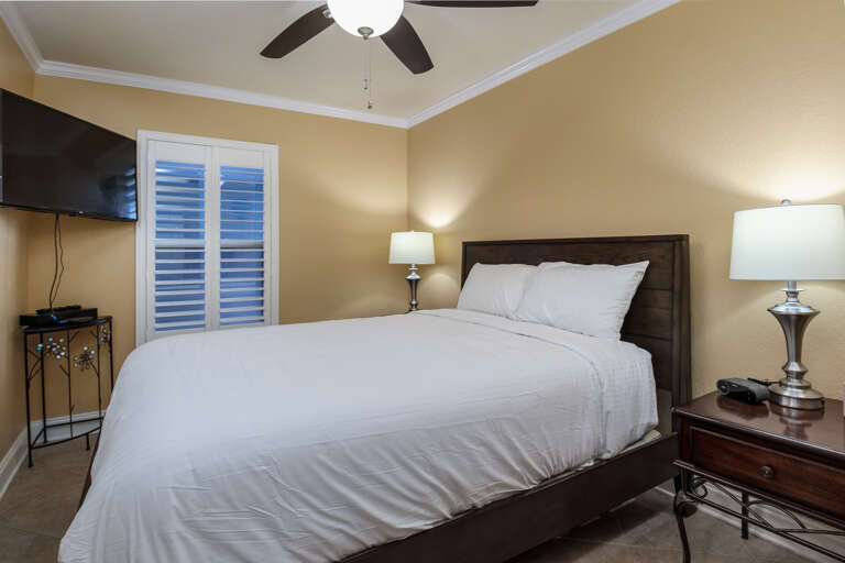 Another view of the guest bedroom which includes a TV. 