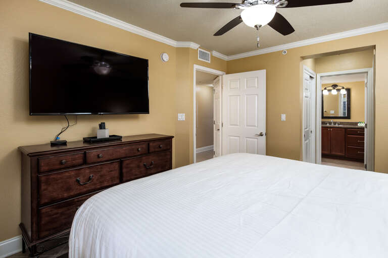 Facing a flat screen TV with a private bathroom to the side