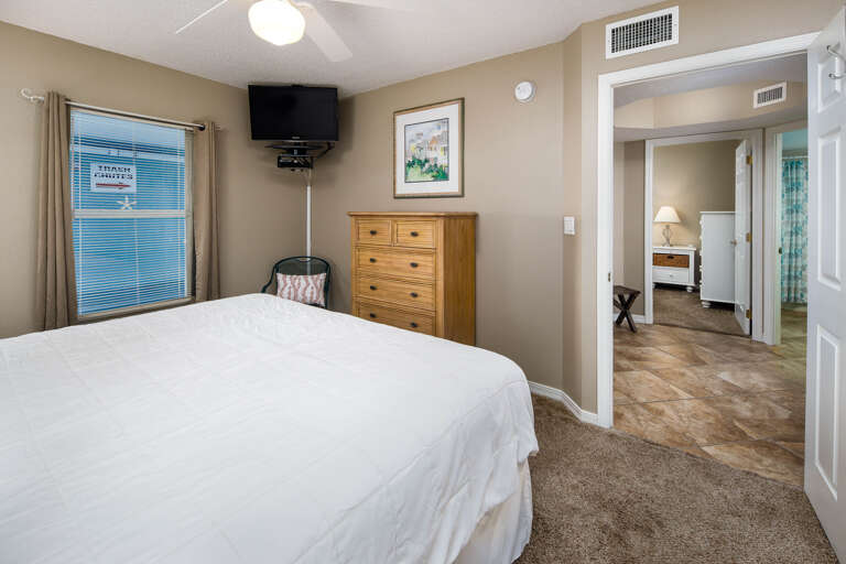 With a mounted TV and private bathroom to the side