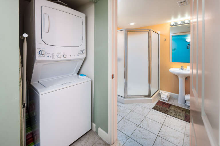The guest bath has a stand-up corner shower stall and a 3-tier shelf to hold linens, towels and toiletry items.