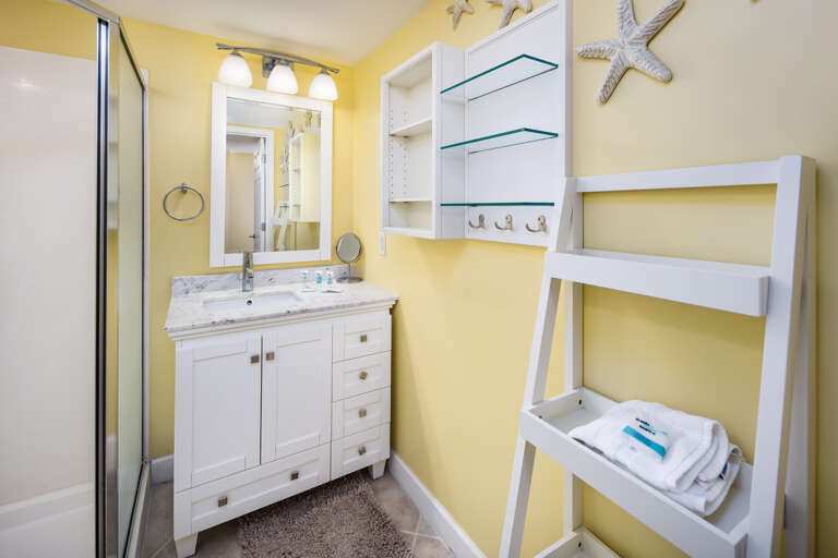 Roomy walk-in shower with STORAGE for personals and again a hair dryer on wall for extra convenience.