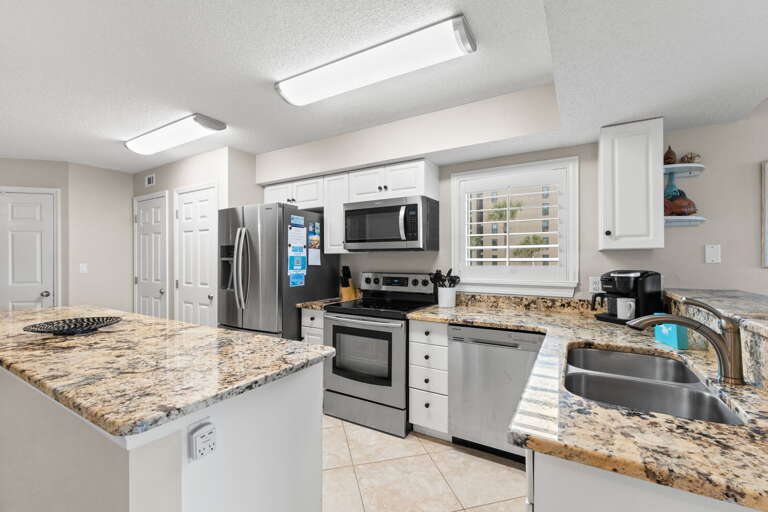 Stainless steel appliances, white cabinetry, endless counter space 