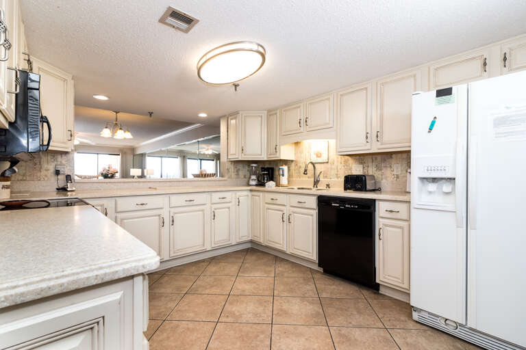 This view shows the side by side refrigerator and freezer, the dishwasher and the sink with disposal.
