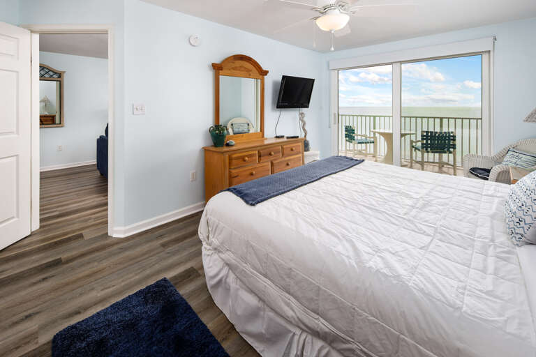 Facing a flat screen TV with a private bathroom to the side