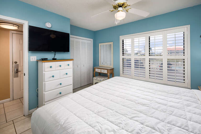The spacious bedroom includes a comfortable king-size bed, flat screen TV, and plenty of drawer space.