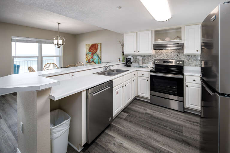 Full service kitchen with white cabinetry and stainless steel appliances  Full service kitchen with white cabinetry and stainless steel appliances