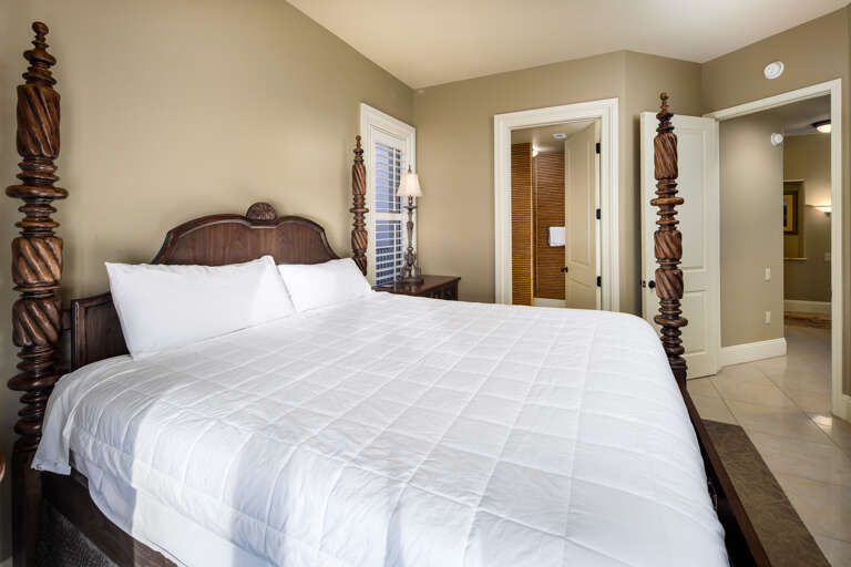 Intricately made dark wooden four-post bed in the first guest bedroom reached after entry. It has everything LUXURIOUS for the ultimate guest experience.