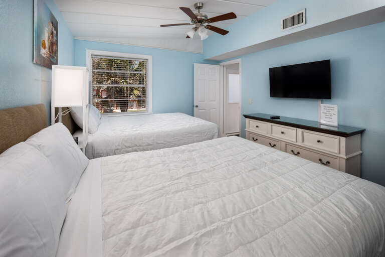 Both beds facing a flat screen TV