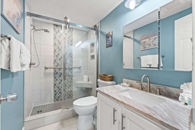 Beautiful clear glass enclosure in this bathroom; perfect for unwinding after a long day on the beach!