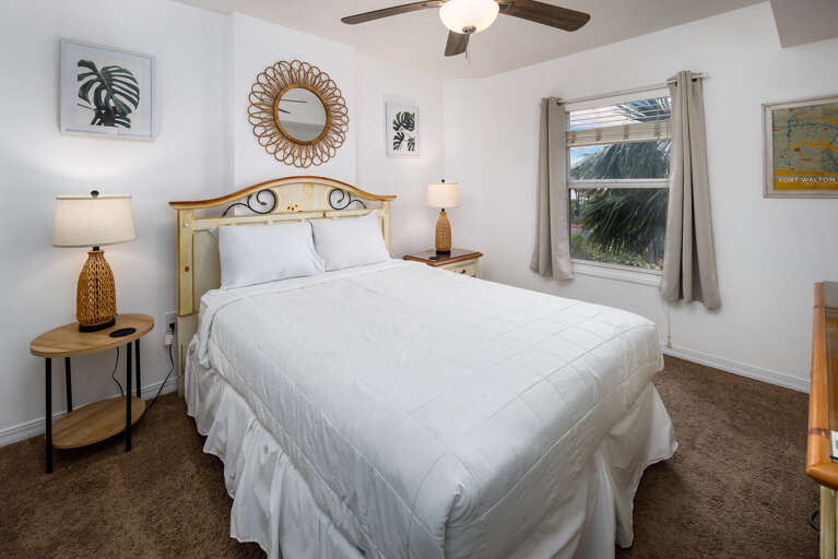 Guest bedroom with a spacious queen bed creates a peaceful space for relaxing and recouping after a long day on the beach.
