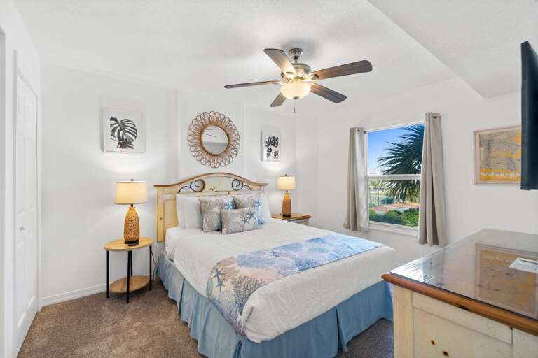 Guest bedroom with a spacious queen bed creates a peaceful space for relaxing and recouping after a long day on the beach.