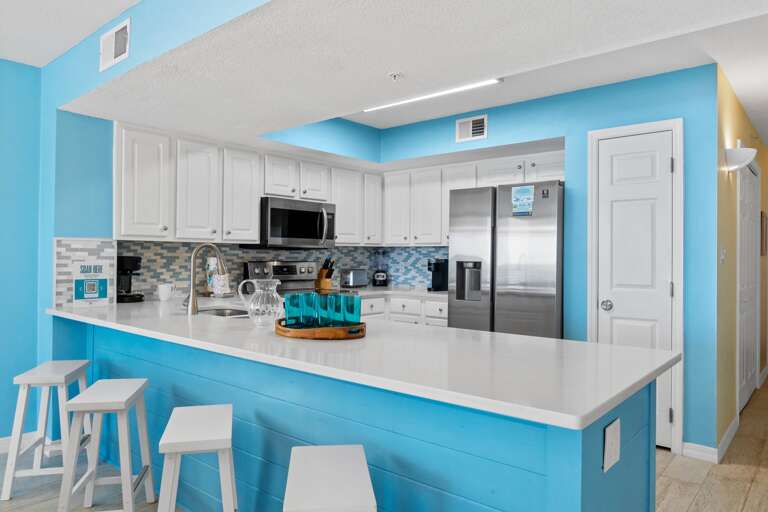 Fully stocked kitchen with ample space on the quartz counter tops for meal preparations and added space for entertaining.