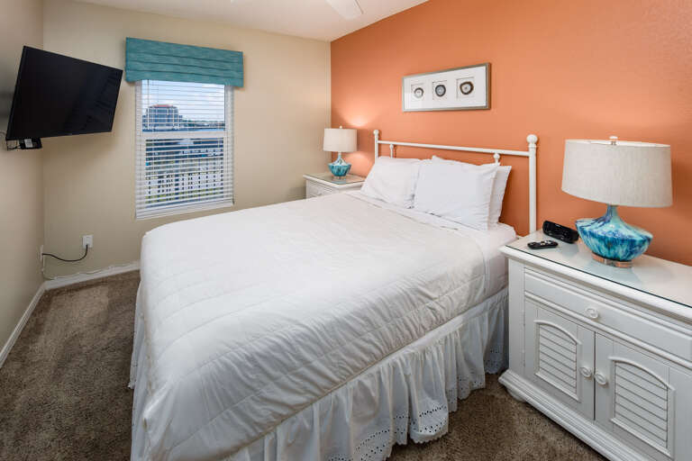 Comfy queen sized bed with coastal furnishings and paint!