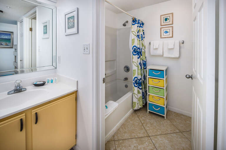 The bathroom features a shower / tub combo and more storage space.