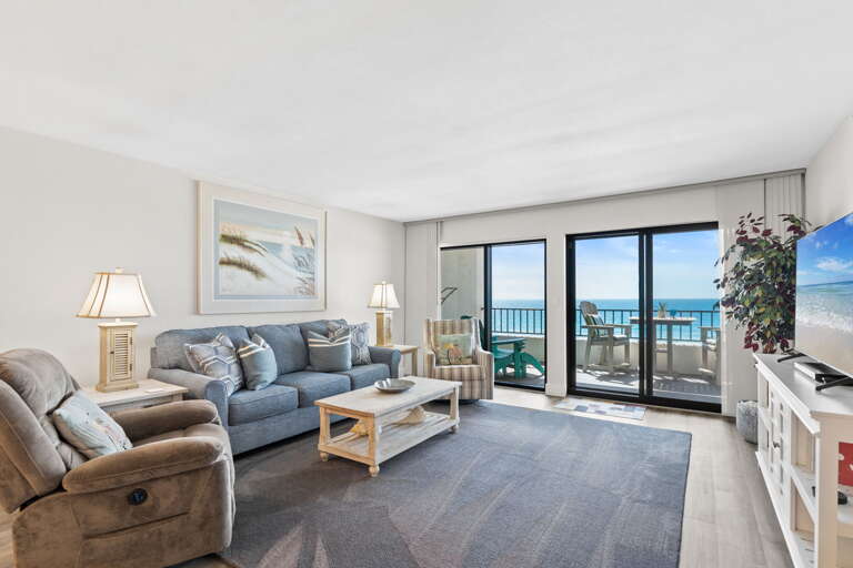 Relax in the living room while enjoying stunning ocean views from the balcony.