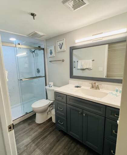 Step into a bright master bathroom with a stunning countertop and walk-in shower, just steps from the beac