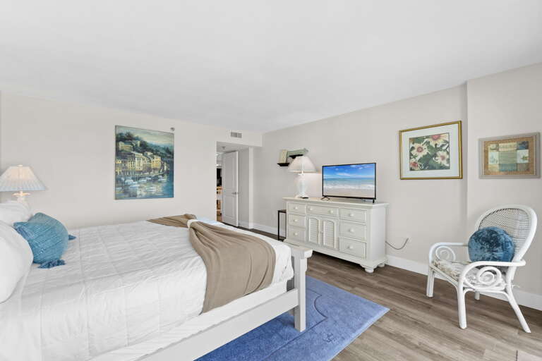 Unwind in the master bedroom with a king bed, TV, and balcony access for mornings by the sea.