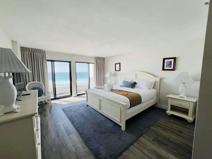 Cozy master bedroom with a king bed and direct access to the balcony.