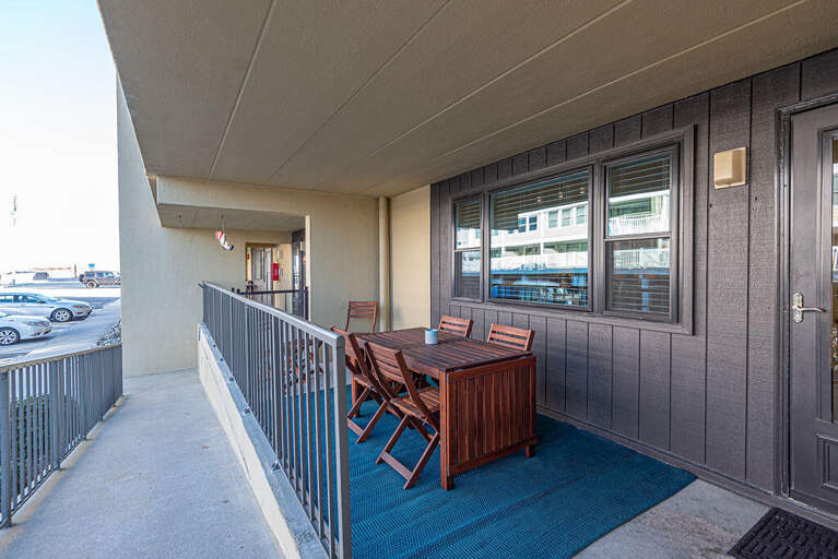 Balcony Of A Vacation Rental With Table And Chairs, Overlooking A Parking Area