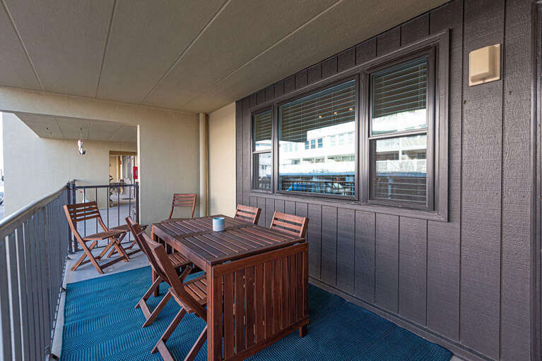 Balcony With Wooden Table And Chairs, Blue Floor, City View