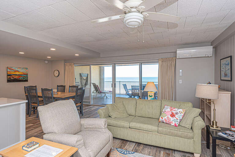 Seaside Vacation Rental Room With Sofa, Chairs, And Balcony View