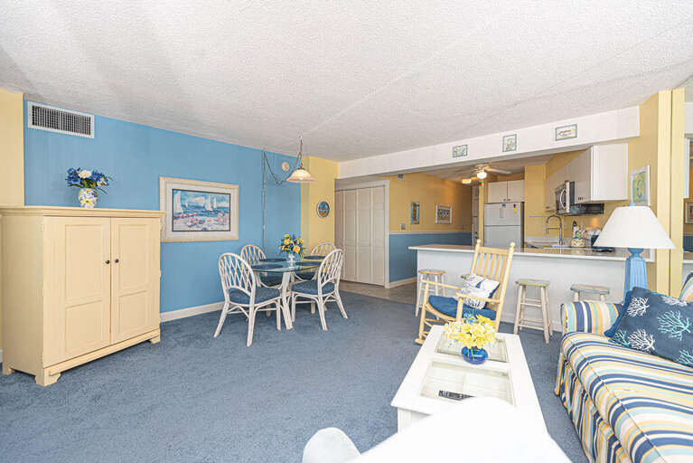 Blue-themed Living Space With Striped Sofa And Dining Area