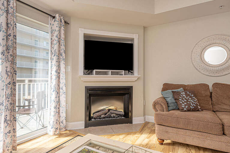 Sunlit Sitting Space With Sofa, Fireplace, And Balcony Access