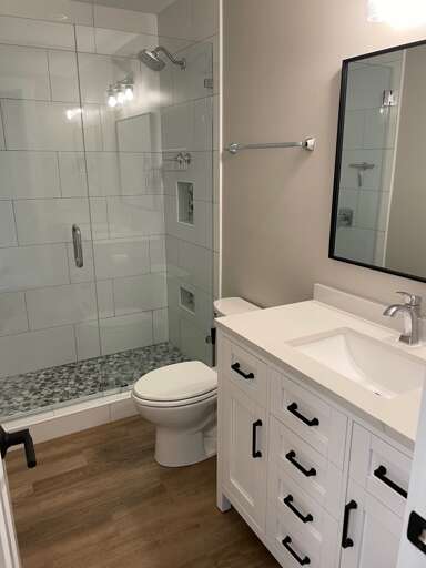 fully renovated guest bathroom with new tiled walk-in shower, flooring and vanity. 