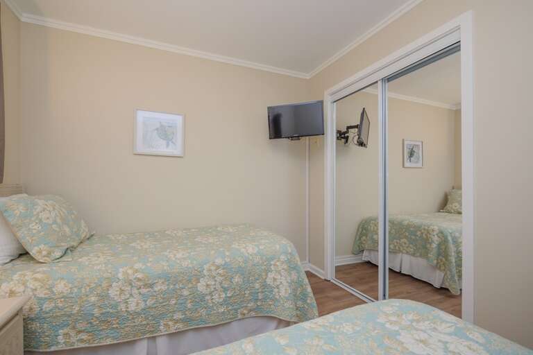 Guest bedroom has wall mounted TV and plenty of space in the closet.