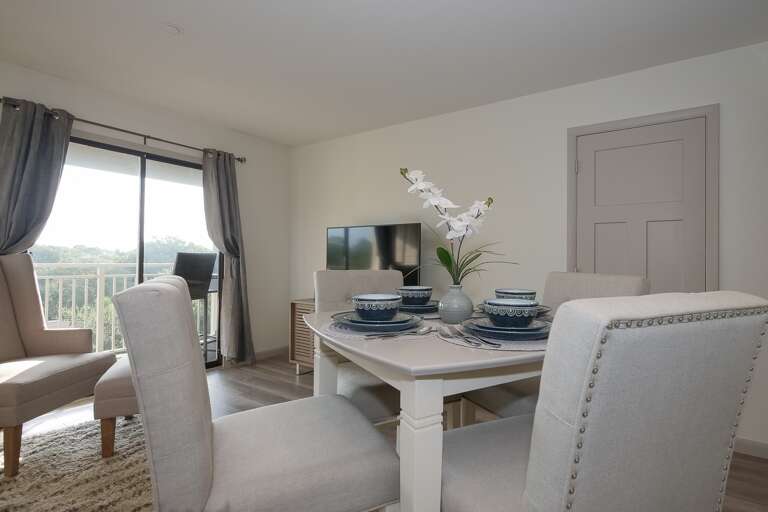 Dining and living room area with glass sliding door to balcony offers side view of the amazing Atlantic ocean .