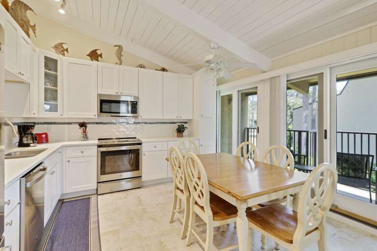 White Kitchen Interior With Dining Table And Sliding Door