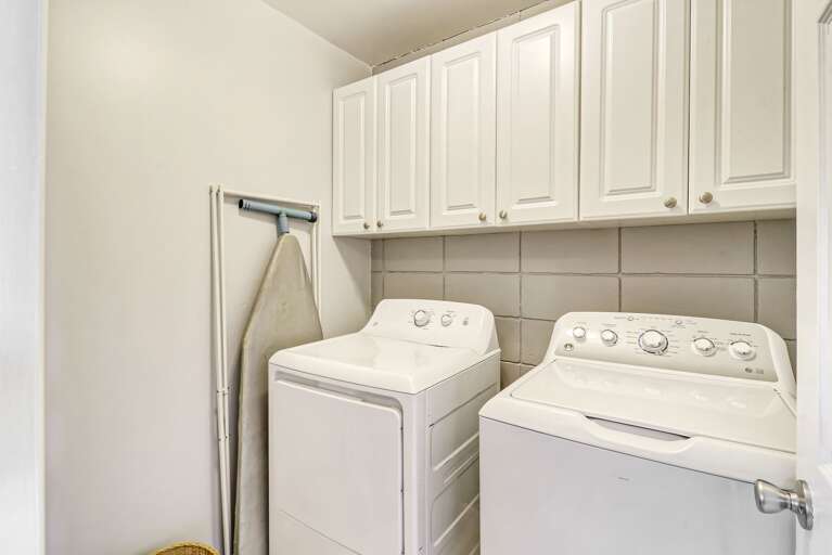 The Laundry room is equipped with a full sized washer and dryer and ironing board.