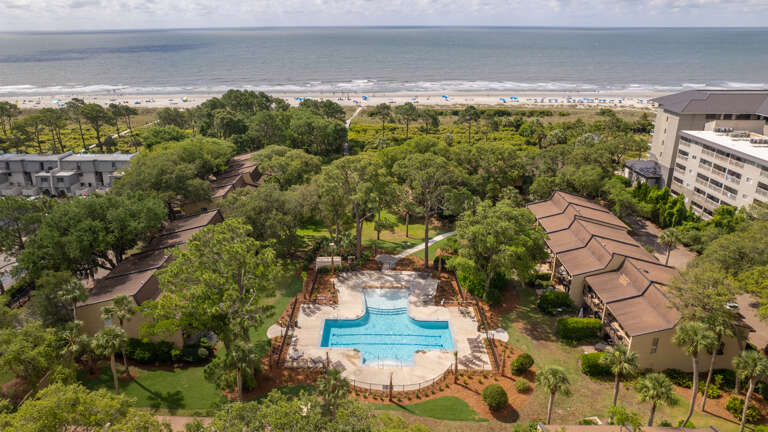 Aerial View Of A Vacation Rental Complex With Pool Near Beach
